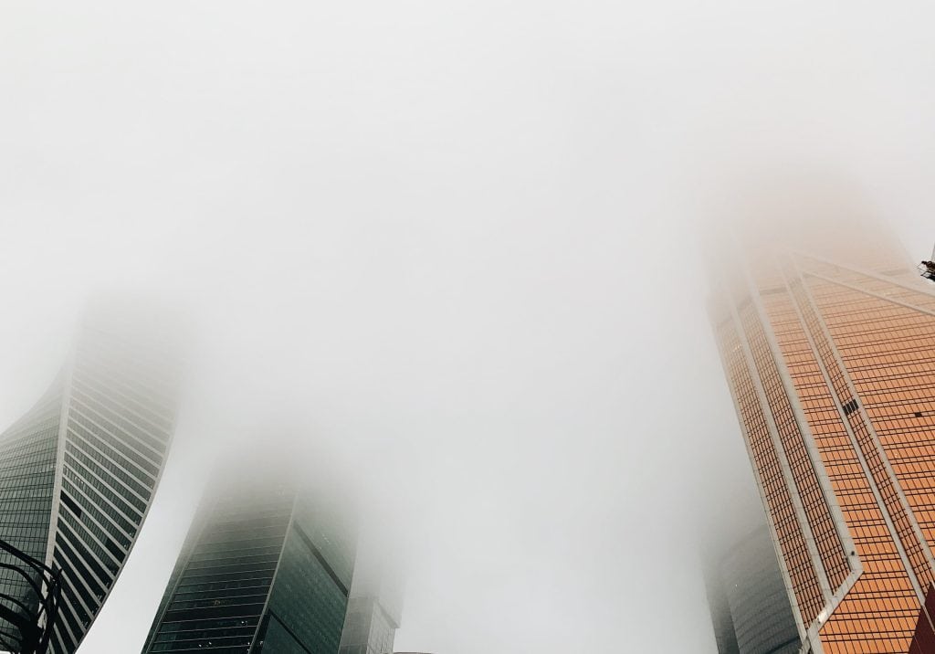 Modern skyscrapers shrouded in fog in Sydney, showcasing contemporary architecture and urban skyline.
