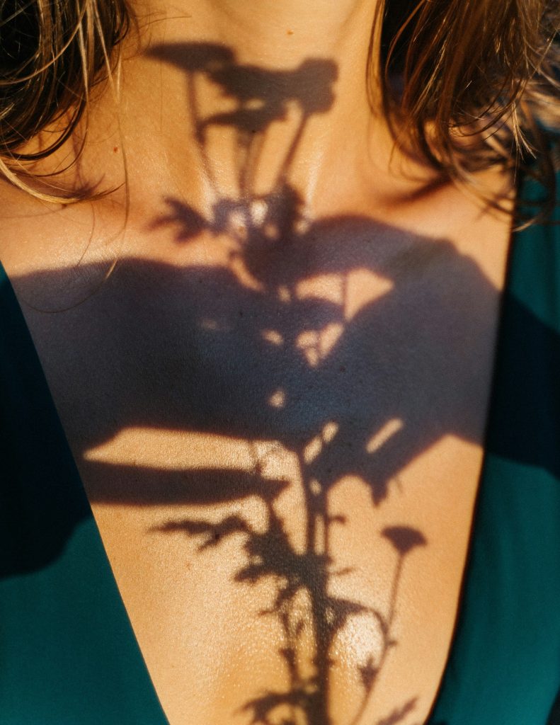 Shadows of a bicycle and flower on a person's chest illuminated by sunlight, symbolising nature and cycling lifestyle.