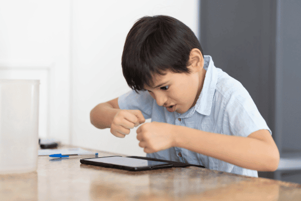 Boy frustrated with tablet, difficult problem, learning challenge, modern education, youth struggling, technology in education, searching for solutions, childhood learning difficulties, tablet device, education technology.